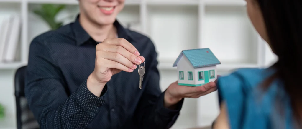 real estate agent handing over keys to new homeown 2025 01 10 12 51 57 utc min scaled